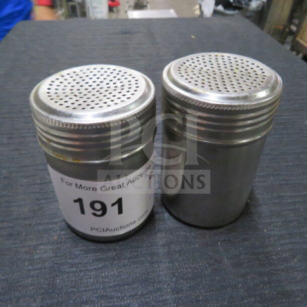 Stainless steel dredge shakers, set of two, perforated lids, item tag 191 visible, used condition.