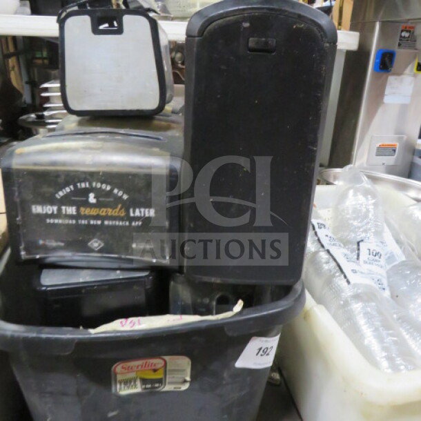 Lot of tabletop napkin dispensers in used condition, featuring branding and "Enjoy the rewards later" text. Multiple units included in a container.