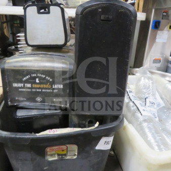 Lot of tabletop napkin dispensers in used condition, featuring branding and "Enjoy the rewards later" text. Multiple units included in a container.
