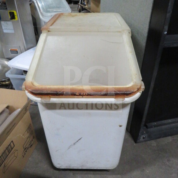 White ingredient bin on casters with a hinged lid, showing signs of use. Ideal for kitchen storage and mobility.