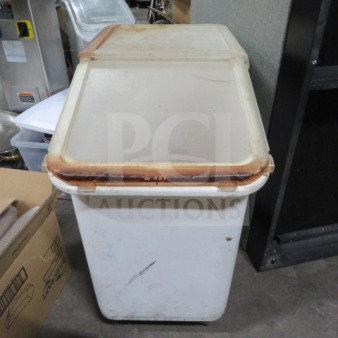 White ingredient bin on casters with a hinged lid, showing signs of use. Ideal for kitchen storage and mobility.