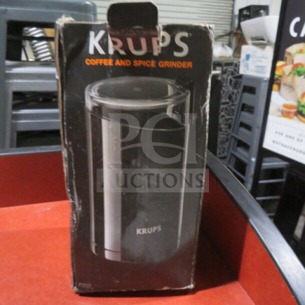 Krups Coffee Grinder in worn packaging, black model pictured on box, used for grinding coffee and spices.