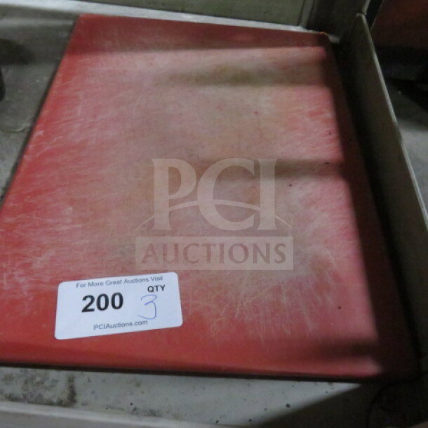 Red cutting board with visible wear marks, marked with sticker "200 QTY 3," from auction site PCI Auctions.