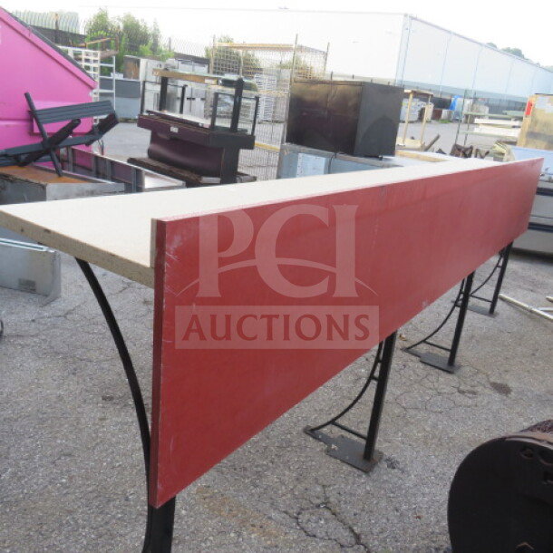 Stand-alone laminate bar with four metal bases, measuring 138x19x45 inches. Features a red finish. Good condition.