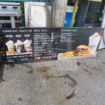 Hanging menu board, 72x25 inches, featuring milkshakes, kids' menu, and meal deals. Likely for a burger restaurant.