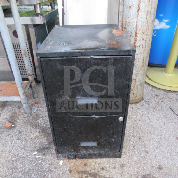 Black metal 2-drawer file cabinet, 14x18x25 inches, noticeable wear and rust. Secure lock, simple design.