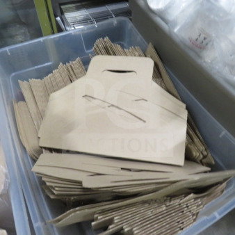 Cardboard drink carriers in bulk, neatly stacked in a plastic bin, suitable for carrying multiple drinks.