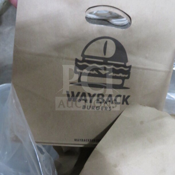 Stack of Wayback Burgers paper bags, featuring burger logo and carry handle, in new condition.