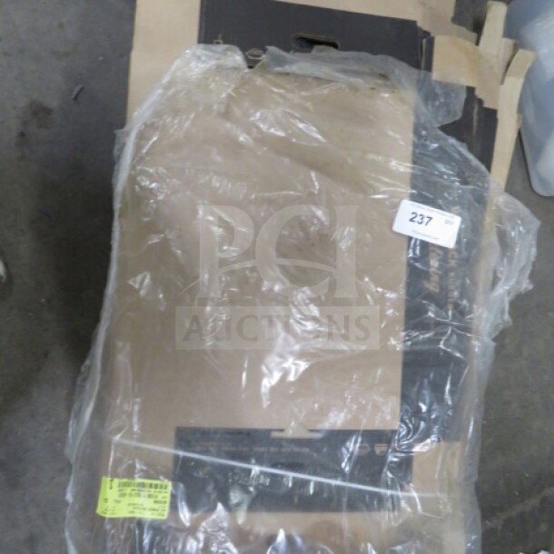 A lot of catering boxes wrapped in plastic. Boxes are stacked, with a label numbered "237". Some labels on packaging.