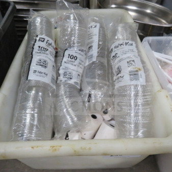 A bin containing assorted cup lids, including packs labeled Fabri-Kal, 100 count, clear plastic.