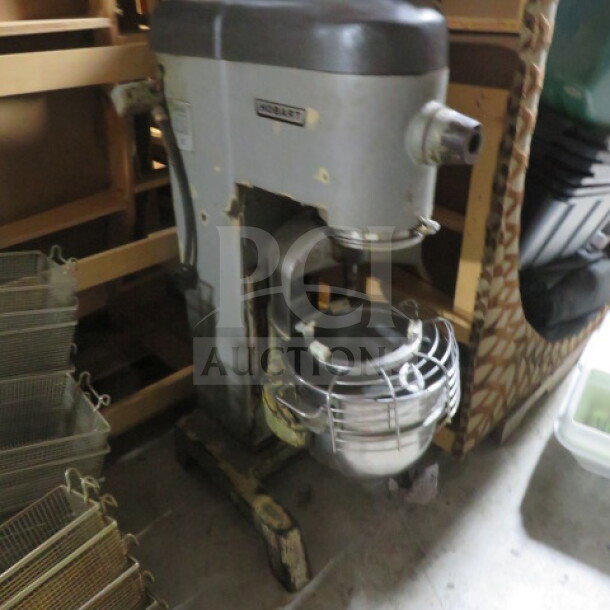 Hobart D330 30-quart stand mixer with stainless steel bowl, safety guard, and paddle. Some wear visible. Operates at 208 volts.
