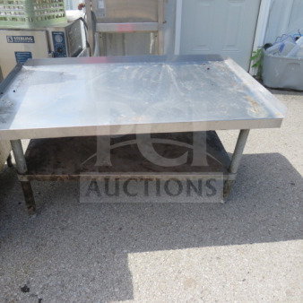 Stainless steel equipment table with undershelf, 48x30x25 inches. Shows signs of wear. Ideal for kitchen or industrial use.