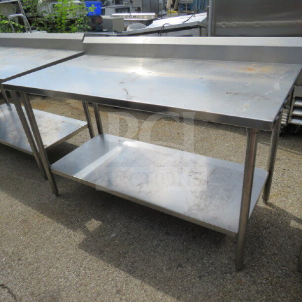 Stainless steel table with SS under shelf and backsplash, measuring 60x30x40. Good condition, ideal for kitchen use.