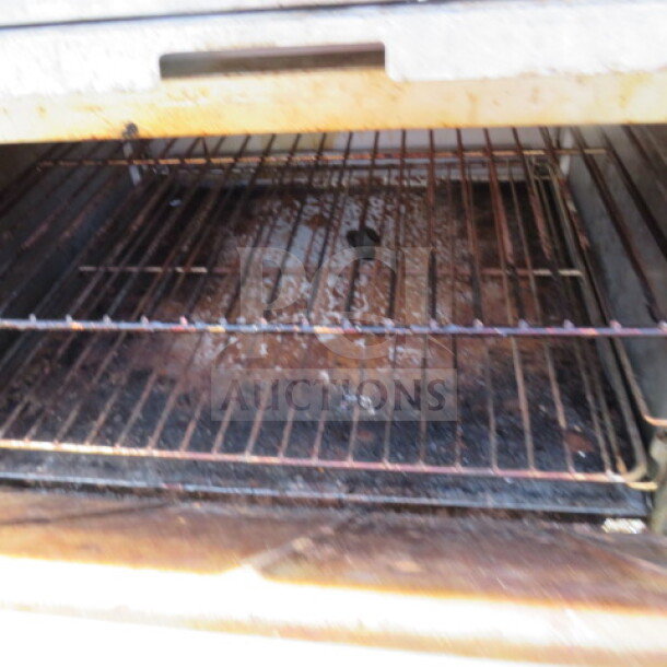 Alt text: Interior of a Motak MR10-C-S natural gas range oven, showing metal racks with signs of use.
