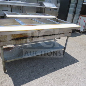Eagle 4 well steam table with undershelf and cutting board, dimensions 64x30.5x34, used condition, visible wear.