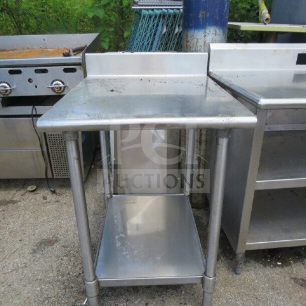 Eagle stainless steel table with under shelf and backsplash, measures 24x30x38 inches, good condition.