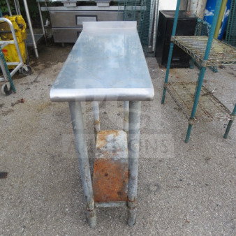 Stainless steel table with under shelf, dimensions 12x30x34.5 inches, showing signs of rust and wear.