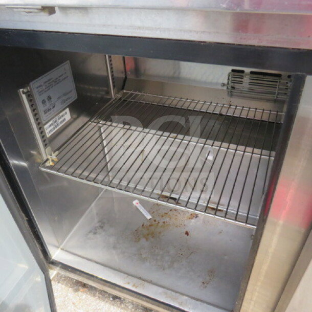 Turbo Air TWR-48SD-N 2-door worktop refrigerator, includes 2 racks and stainless steel over shelf on casters, model label visible.