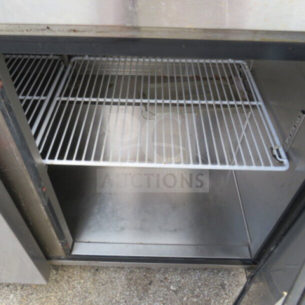 Migali 2-door worktop refrigerator, model C-U48R-HC, with 2 racks and casters. Measures 48x30x64 inches, 115 Volt.