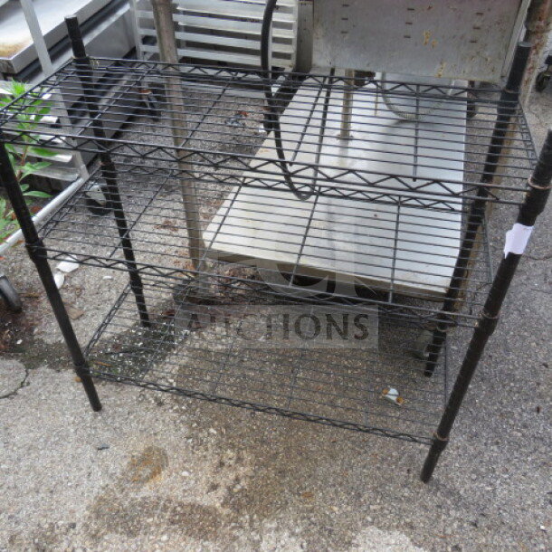 Black Metro shelf with 3 wire shelves, dimensions 36x14x36 inches, made by Metro, minor wear visible, suitable for storage.