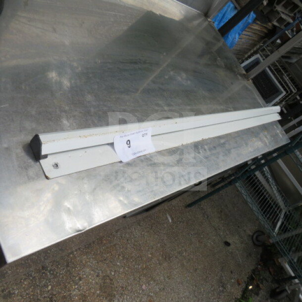 48-inch ticket rail, metal, pre-owned. Features mounting holes and minor wear marks. Auction tag marked "9."