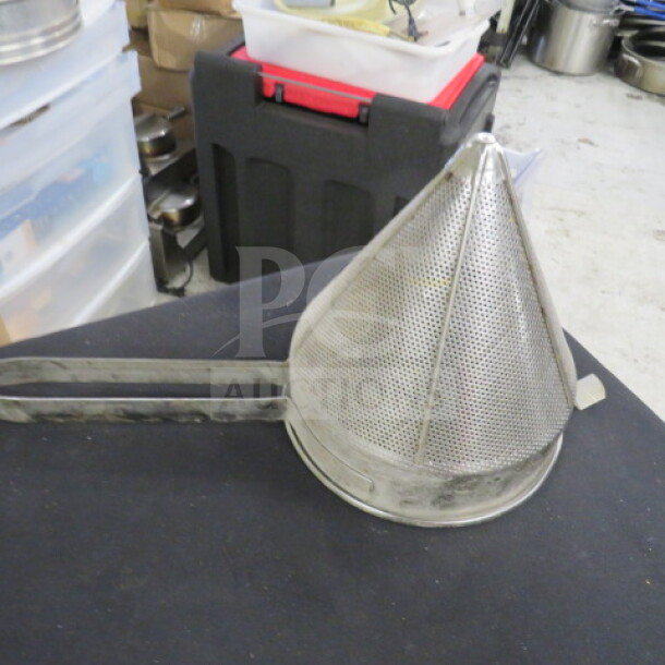 Stainless steel cone strainer, perforated mesh design, with handle, in good condition, ideal for kitchen use.