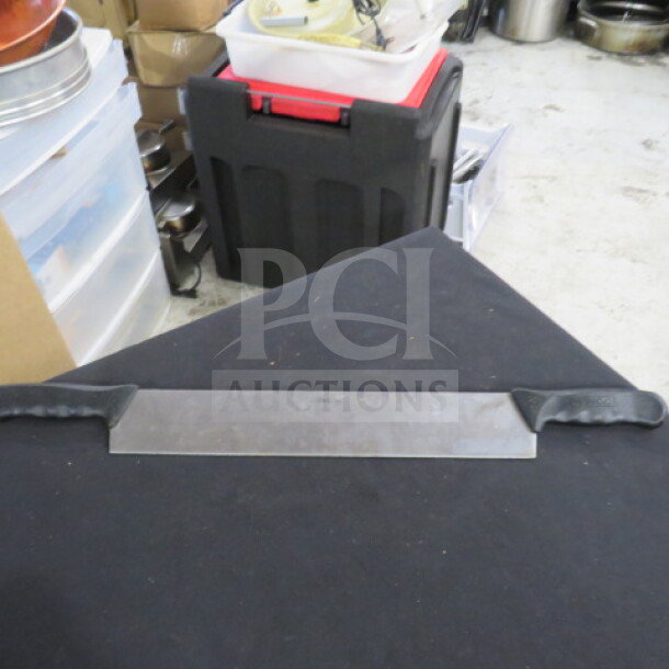 Double handle knife with stainless steel blade and black ergonomic grips. Appears in good condition on a black surface.