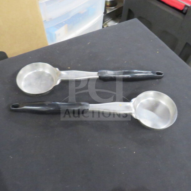 Two stainless steel 4oz spoodles with black plastic handles, in used condition. Ideal for portion control.