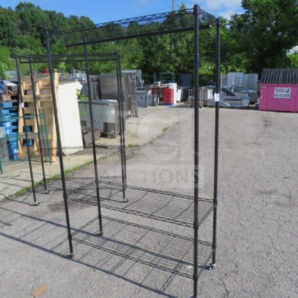 One black Metro shelf with three wire shelves, coat rack, hooks, and casters; dimensions 47x18x75 inches.