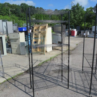 Black Metro shelf unit with five wire shelves, dimensions 36x14x74 inches, in used condition, outdoors.