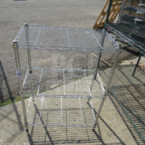 Metal Metro shelf with three wire shelves, dimensions 23x13.5x31 inches. Sturdy construction, used condition. Suitable for storage.