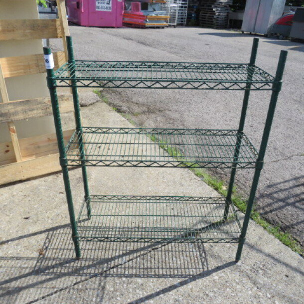 Green Metro shelf unit with three wire shelves, 36x14x44 inches. Sturdy metal construction in good condition.
