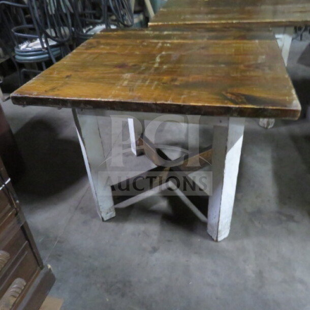 Heavy wooden table top on wooden base, measuring 36x35x30 inches. Features a rustic finish and sturdy cross-braced legs.