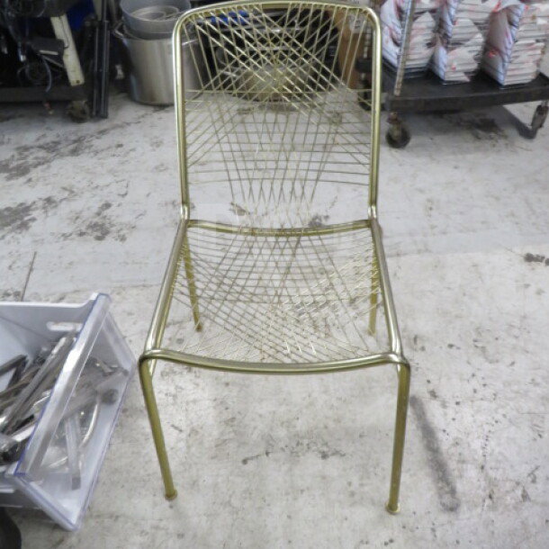 Gold metal chair with intricate wire mesh design, sturdy frame, and sleek finish. Appears in good condition. Model: 2XBID.