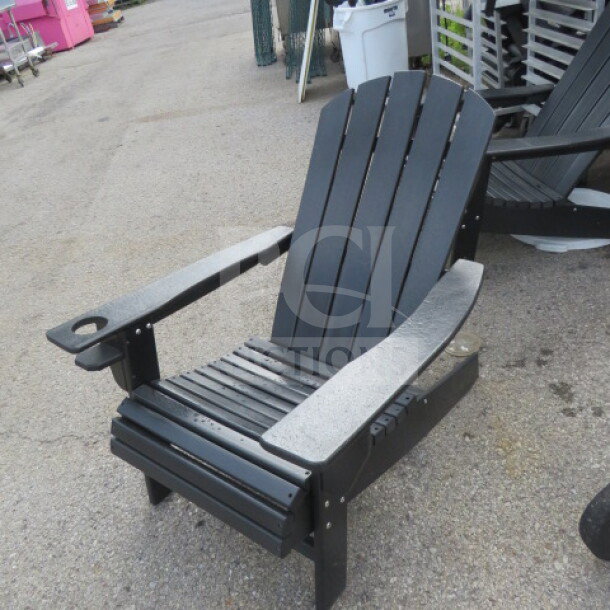 Black composite Adirondack chair with cup holder, excellent condition, durable design, ideal for outdoor use.
