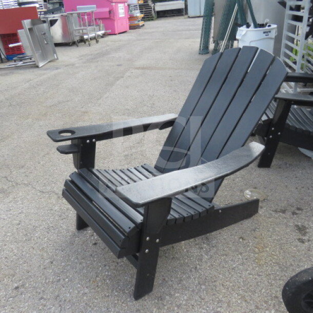 Black composite Adirondack chair with integrated cup holder, sturdy slatted design, appears in good condition.