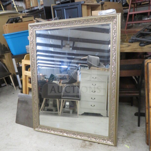 43x55 inch gold framed mirror with ornate detailing, rectangular shape, in good condition. Ideal for decor or practical use.
