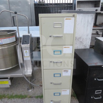 Four-drawer metal file cabinet, cream color, visible labels, minor wear, standard office size, suitable for document storage.