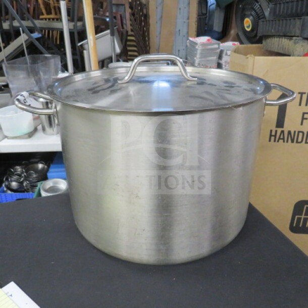 Stainless steel 40qt stock pot with lid, dual handles, metallic finish, in good condition. Ideal for large-scale cooking.