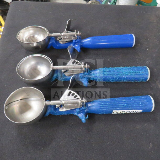 Three blue handle dishers with stainless steel scoops, well-used condition; one handle marked "Pudding," labeled 3XBID.