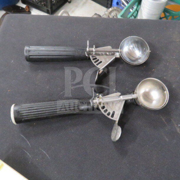 Black handle disher set, 2XBID model. Features metal scoops and ergonomic black grips. Appears in good used condition.