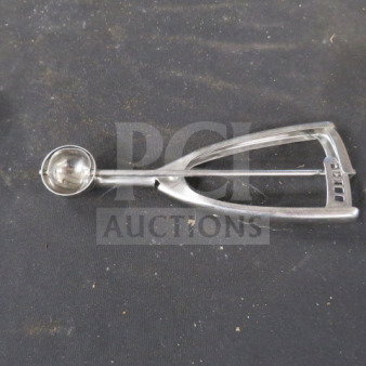 Stainless steel disher with a spring mechanism on a dark background, showing slight wear. Ideal for scooping.