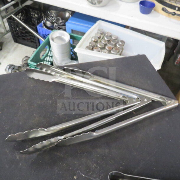 Stainless steel tongs, 12 inches, in good condition, with scalloped edges for grip. Model: 3XBID.