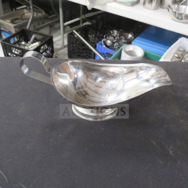 Stainless steel gravy boat, 6XBID model, sleek design, excellent condition, polished finish, curved handle.