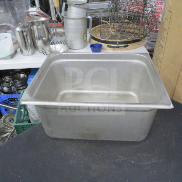1/2 size, 6-inch deep hotel pan in stainless steel. Used condition with minor wear. Ideal for commercial kitchen use.