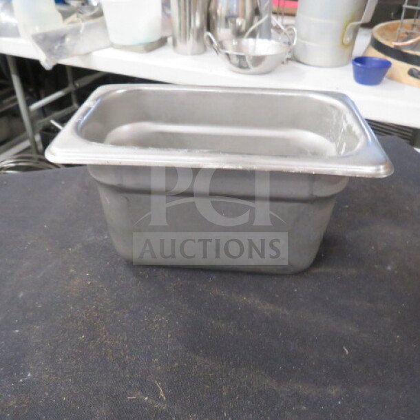 Stainless steel 1/9 size 4-inch deep hotel pan, used condition, ideal for commercial kitchen or catering use.