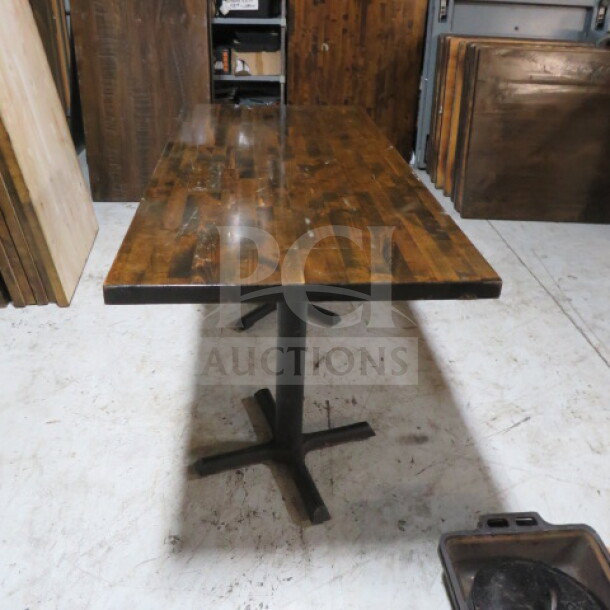 Solid wood butcher block table top, 1-1/2 inch thick, on dual pedestal base. Dimensions: 55x33x30 inches. Rustic finish.