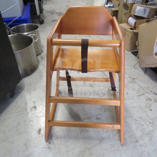 Light oak wooden high chair with safety straps, in good condition. Suitable for toddler use, sturdy design.