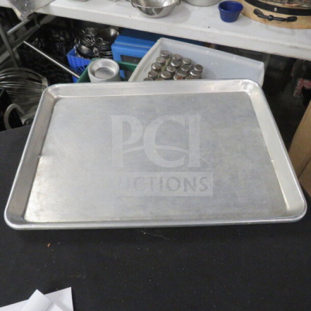 1/2 Size Sheet Pan, silver metal, gently used, flat surface with raised edges. Suitable for baking or roasting. Model 5XBID.