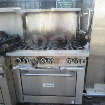 Garland G36 6-burner natural gas range with stainless steel over shelf and 3 racks on casters, 36"x35"x57". Used condition.
